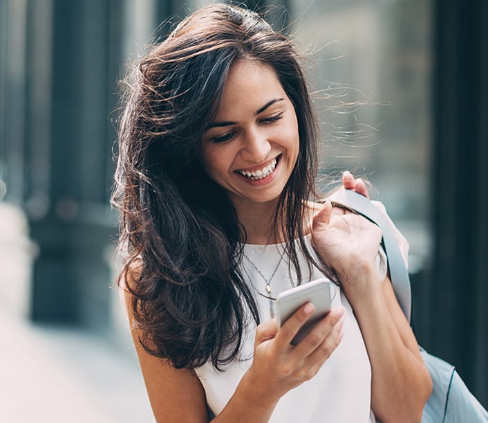 Smiling Woman Looking at Phone Smiling Woman Looking at Phone