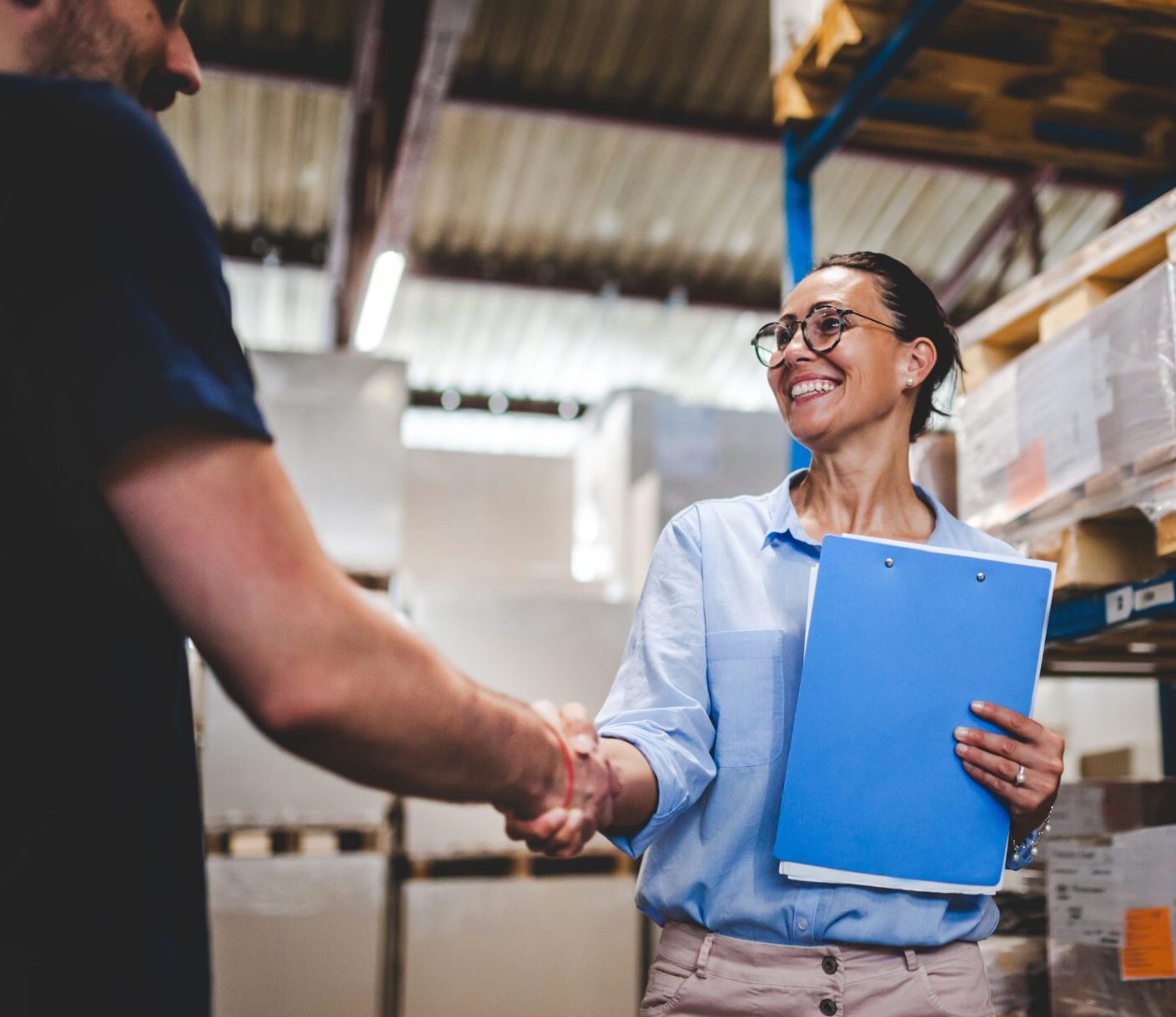 Warehouse supervisor walking and talking with senior manager